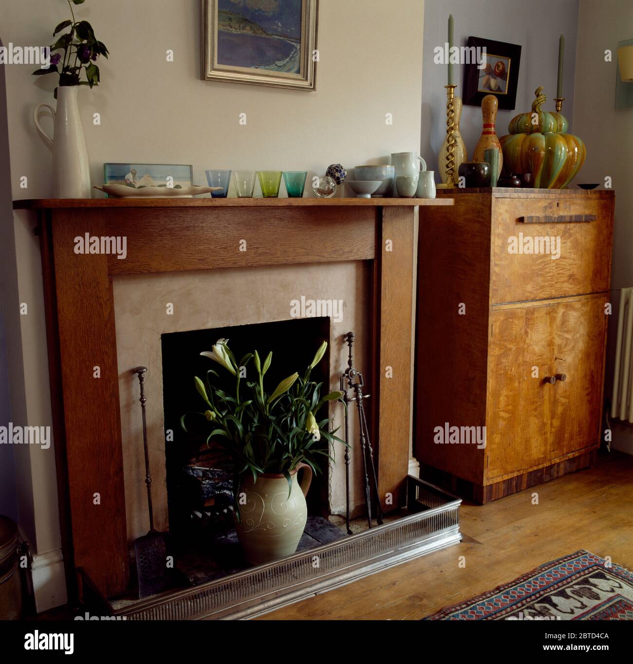 Simple wooden mantelpiece in room with thirties cupboard Stock Photo