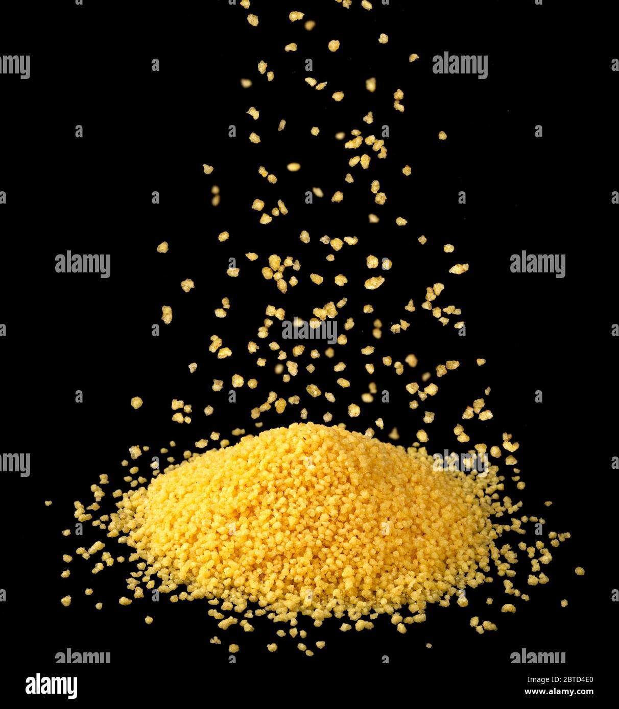 Falling dry couscous groats isolated on black background Stock Photo