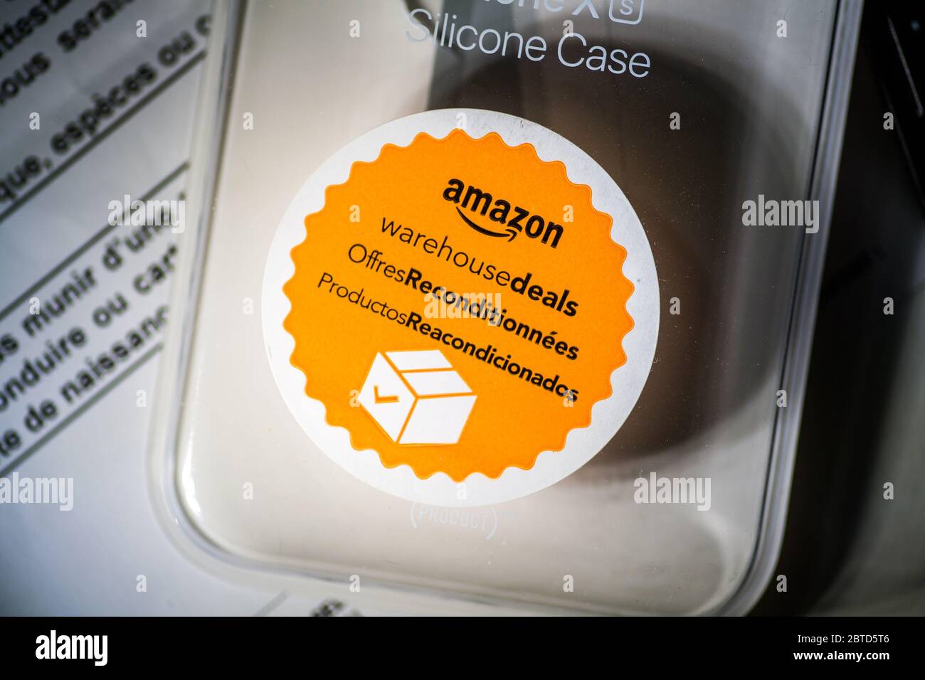 Paris, France - Nov 15, 2019: Amazon Warehouse Deals orange sticker on the package of used pre-owned Amazon Silicone Case Stock Photo