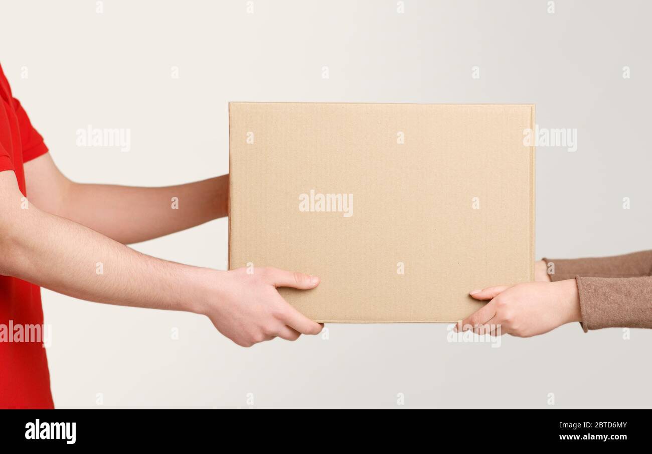Woman hands accepting delivery of box from deliveryman Stock Photo