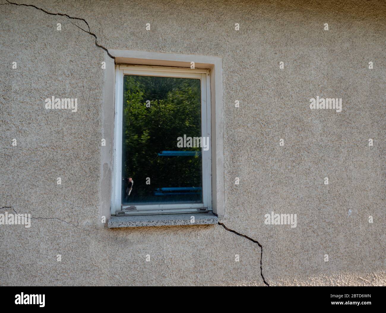 Building damage in a wall at the window cracks Stock Photo