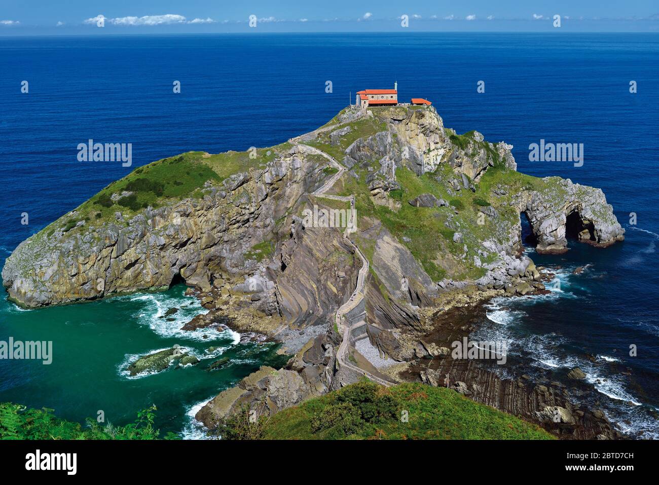 Rocky island with small chapel and stone staircase leading to it Stock Photo