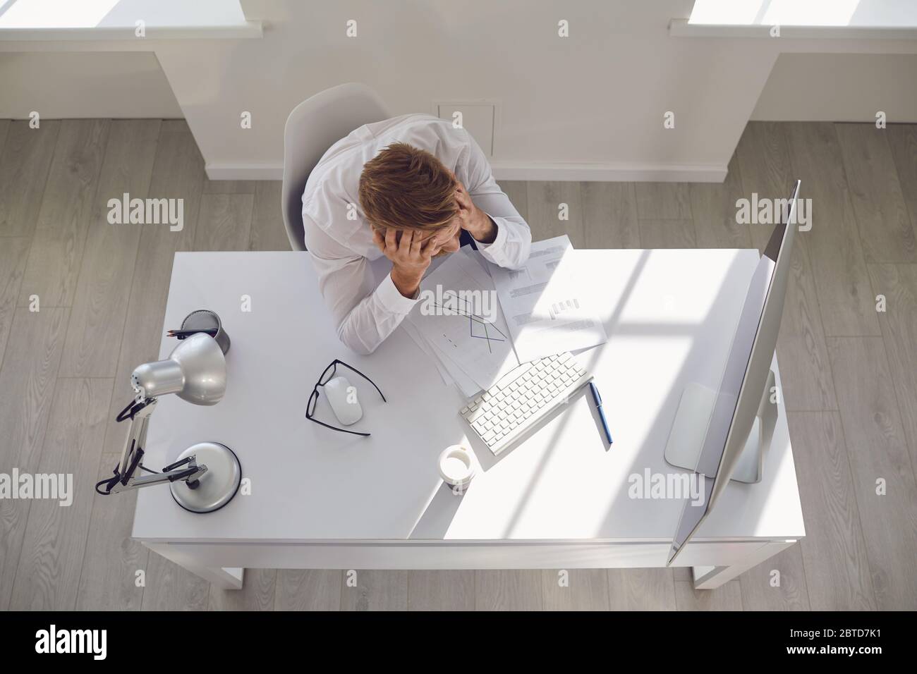 Unemployed businessman in white office. Unemployment. Crisis. Stock Photo
