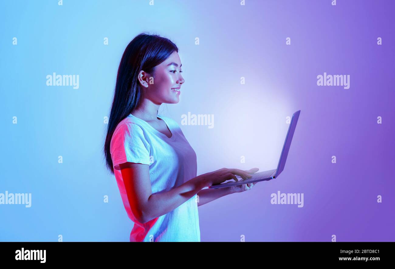 Online work and education. Girl holding laptop with glowing screen Stock Photo