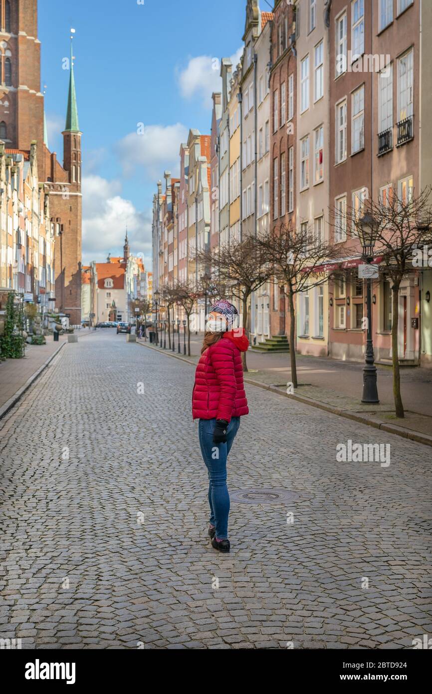 Woman in mask during corona virus (COVID-19) outbreak walking on the streets of Old Town Gdansk, Poland Stock Photo