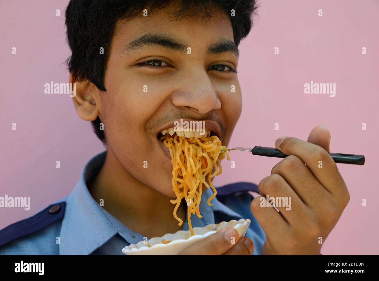 Young adult eating Noodles Stock Photo Alamy