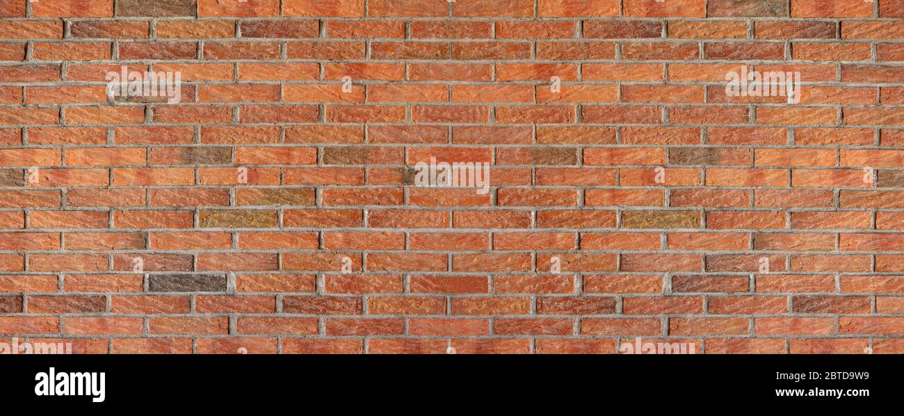 Old, red, roughly worked brick wall Stock Photo