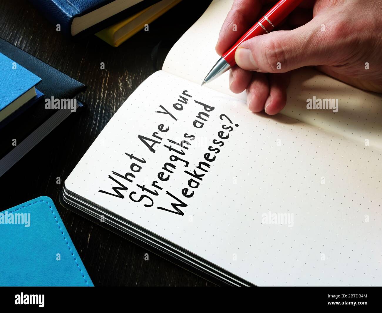 Man writes a question What Are Your Strengths and Weaknesses. Stock Photo