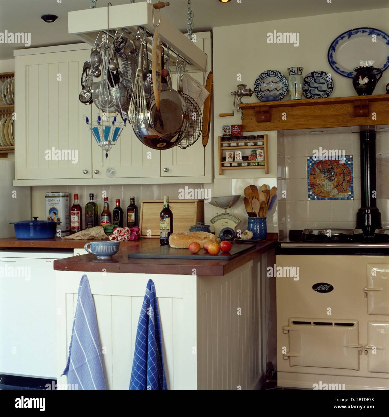 Stainless steel utensils on rack in kitchen with cream Aga Stock Photo ...
