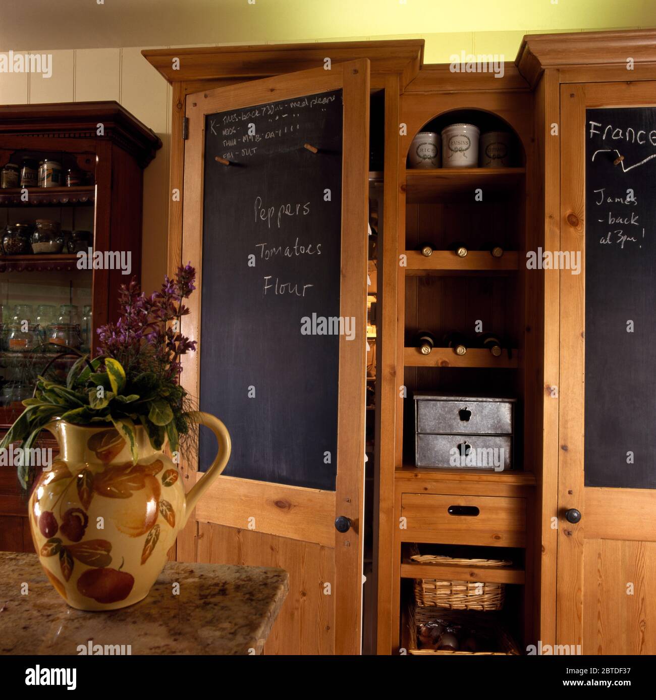 Wooden kitchen storage unit with blackboards on doors Stock Photo