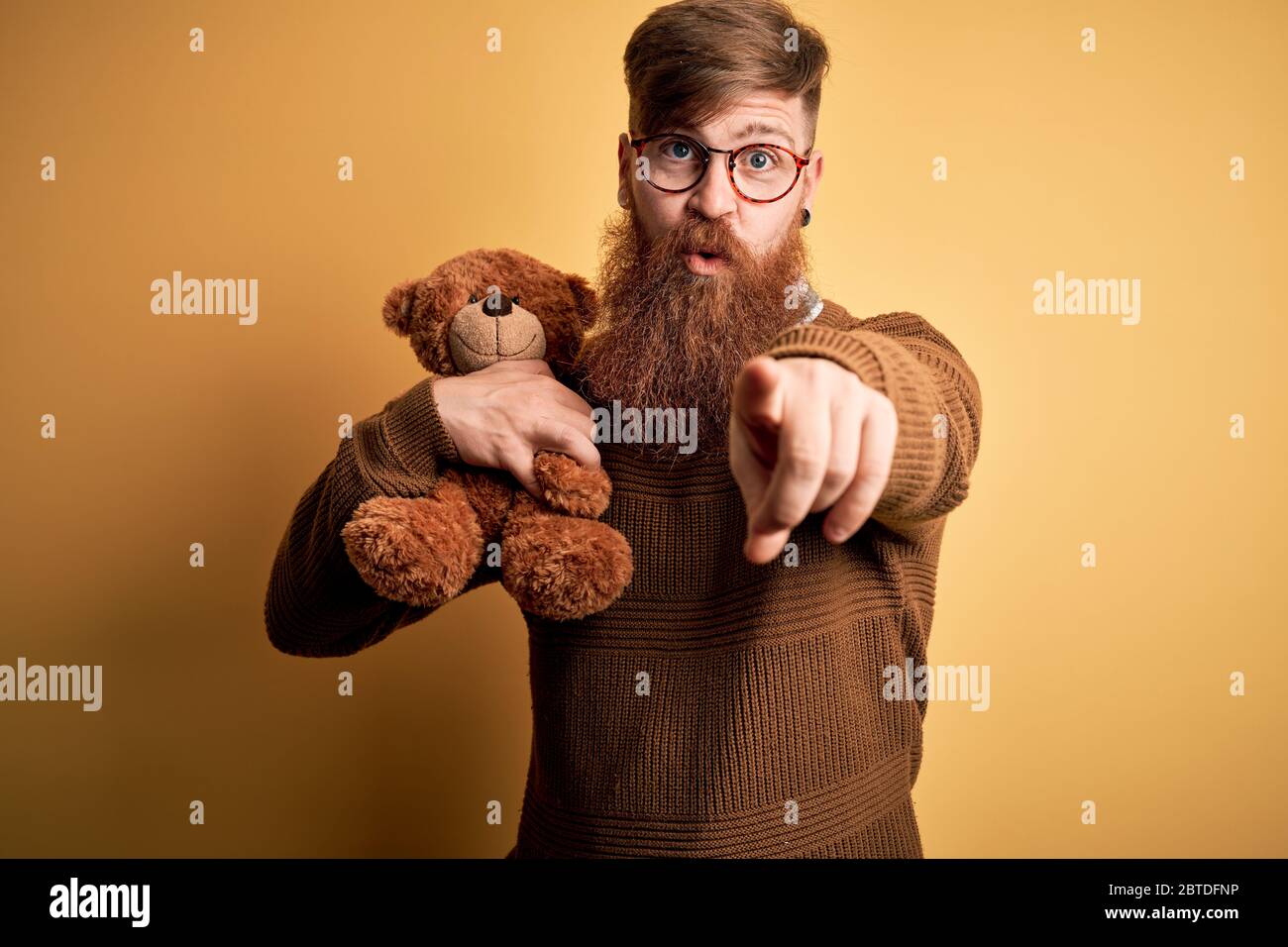 Redhead Irish man with beard hugging teddy bear stuffed animal over yellow  isolated background pointing with finger to the camera and to you, hand sig  Stock Photo - Alamy