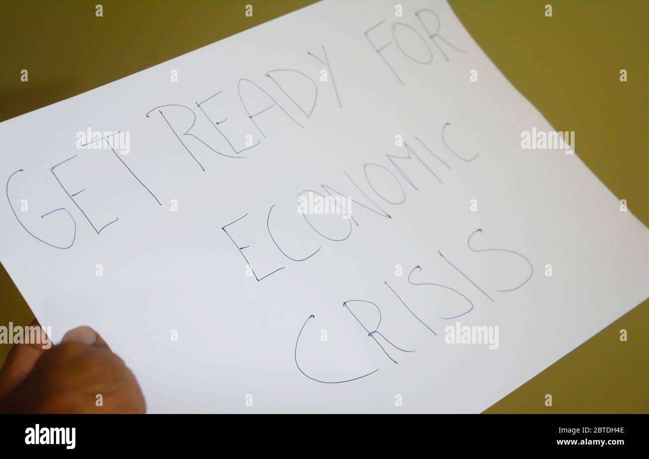 hands holding a paper, get ready for economic crisis text. Stock Photo