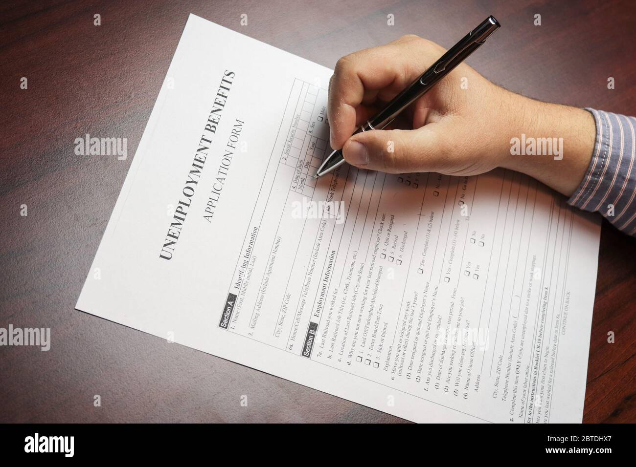 Close-up of a person's hand filing social security benefits application  form. Concept of Covid-19 coronavirus and stay at home order impact on  econom Stock Photo - Alamy