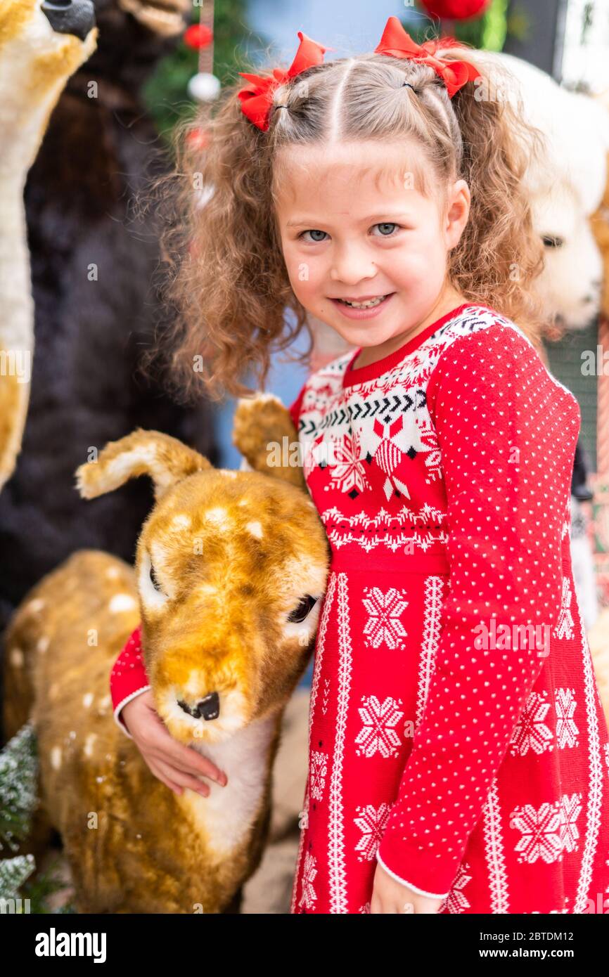 Little girl in red dress at the Christmas tree farm Stock Photo - Alamy