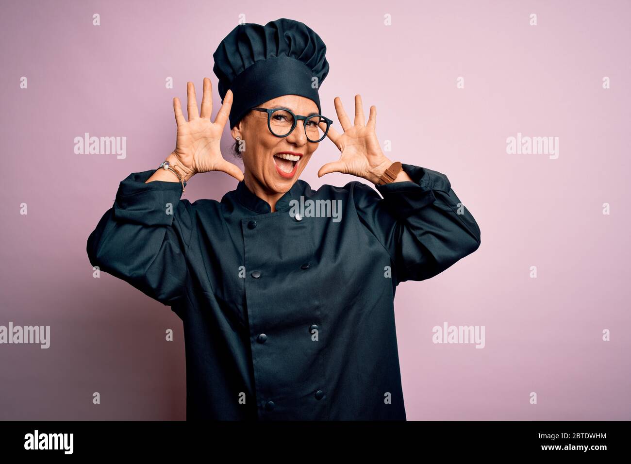 Middle age brunette chef woman wearing cooker uniform and hat over ...