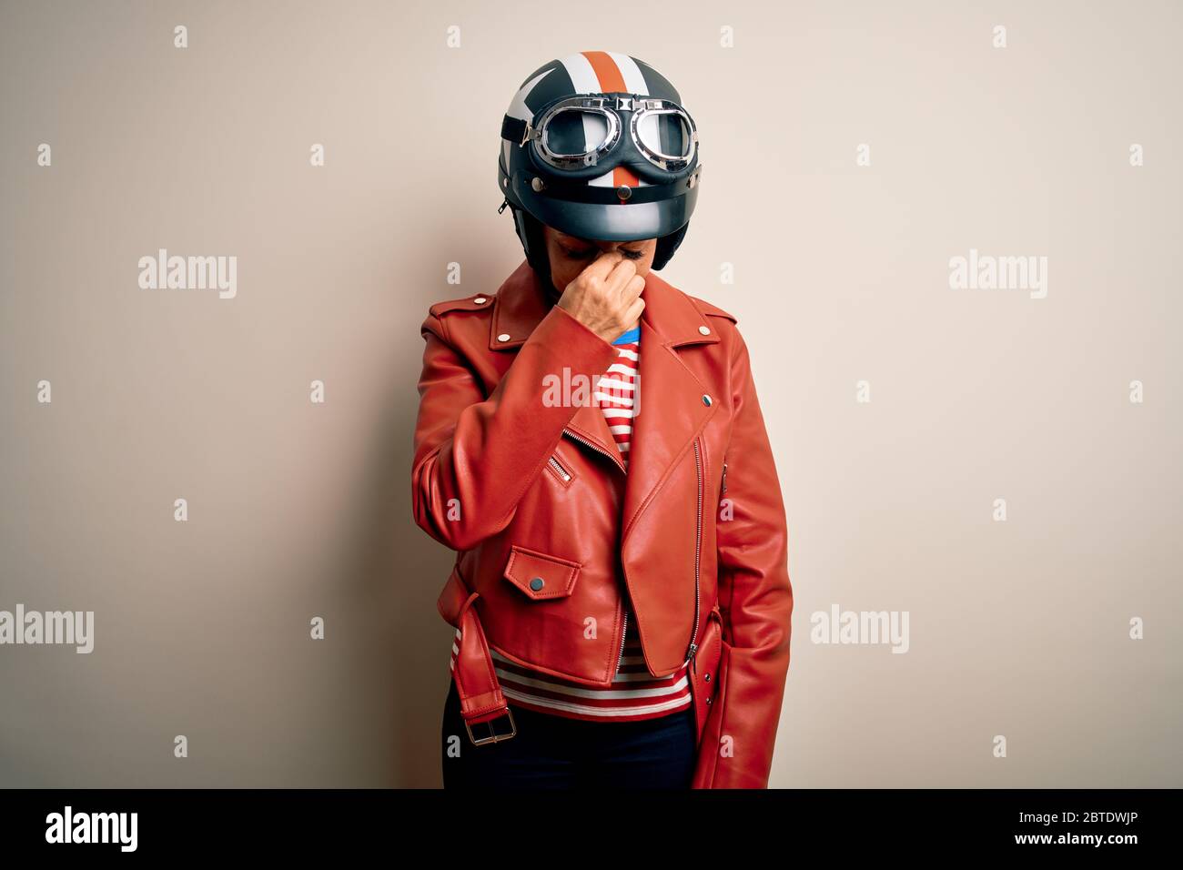 Middle age motorcyclist woman wearing motorcycle helmet and jacket over