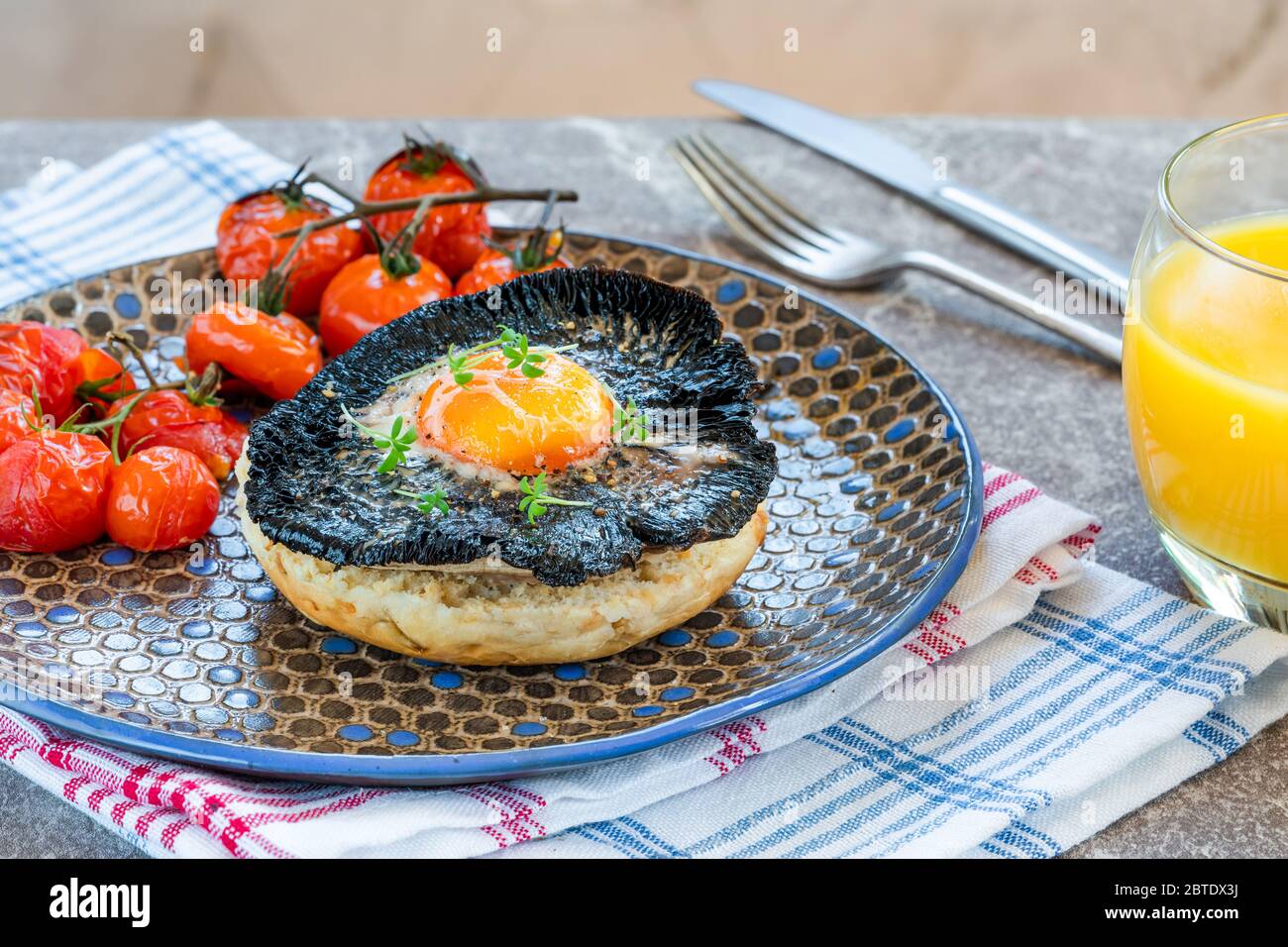 Baked egg and mushroom brunch with baby tomatoes Stock Photo - Alamy