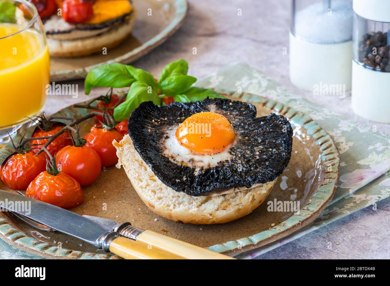 Baked egg and mushroom brunch with baby tomatoes Stock Photo - Alamy