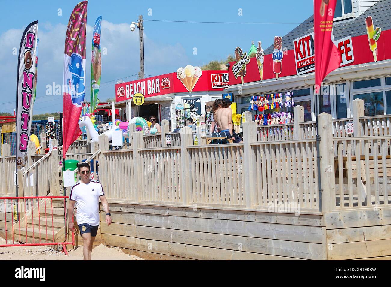 Camber, East Sussex, UK. 25 May, 2020. UK Weather:  Camber Sands, East Sussex. Social distancing sign at the beach bar with people waiting patiently in the queue. Photo Credit: Paul Lawrenson/Alamy Live News Stock Photo