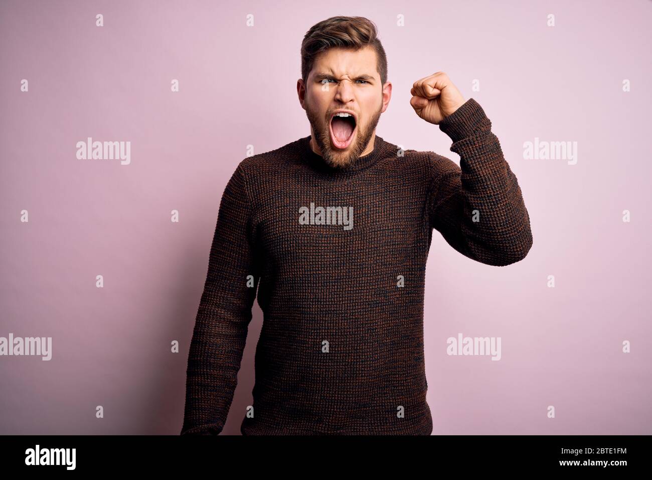 Young blond man with beard and blue eyes wearing casual sweater over ...