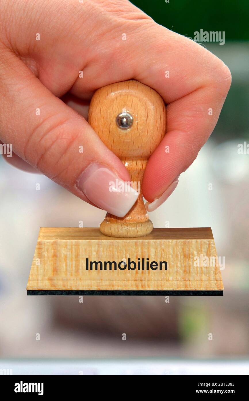 hand with wooden stamp printed with Immobilien Stock Photo