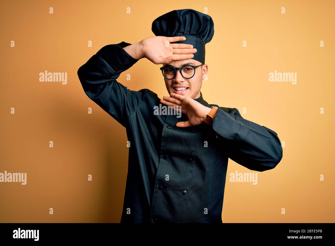 Young brazilian chef man wearing cooker uniform and hat over isolated ...