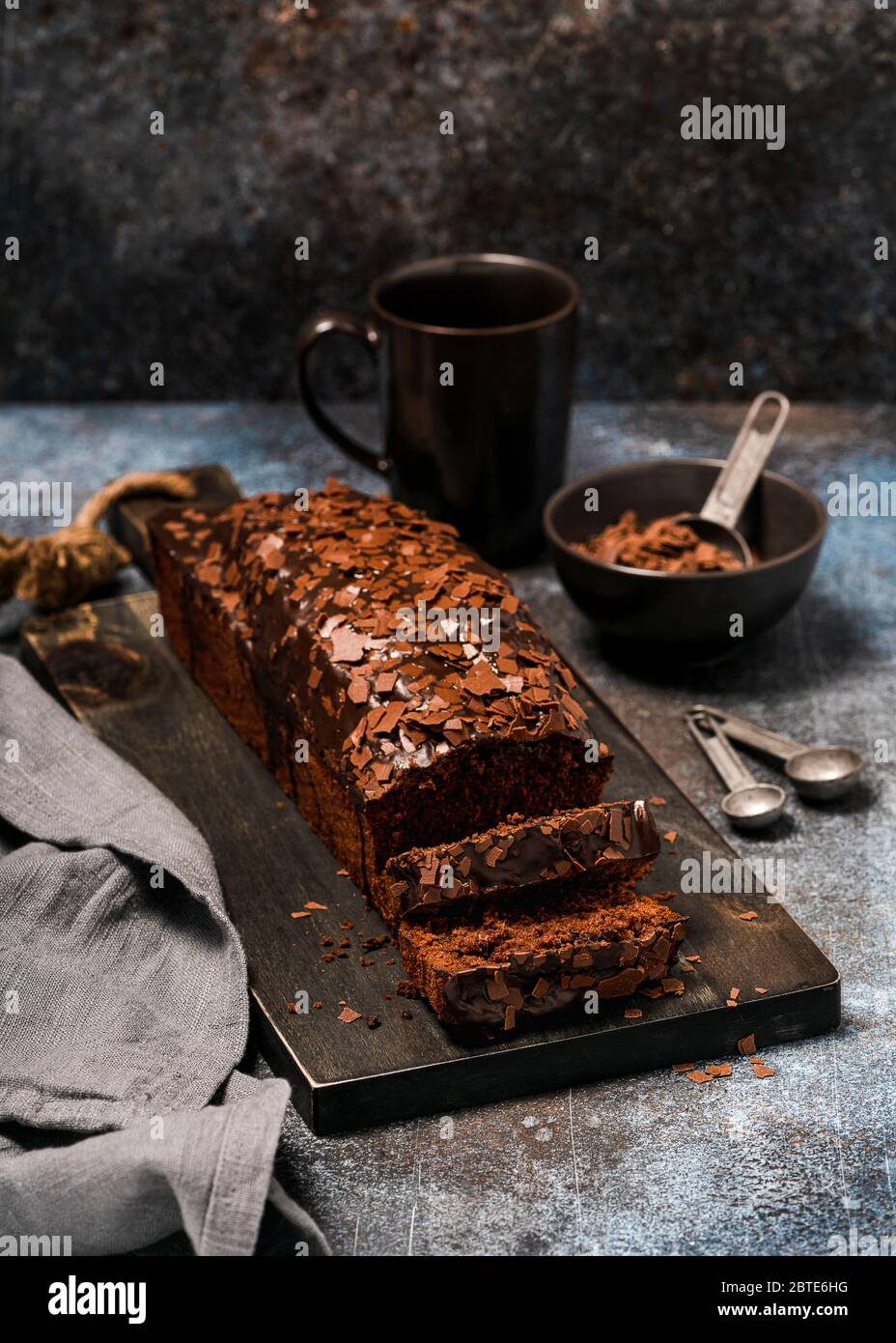 Chocolate cake with chips cut into several pieces. Homemade sweet concept. Rustic style. Selective focus. Stock Photo