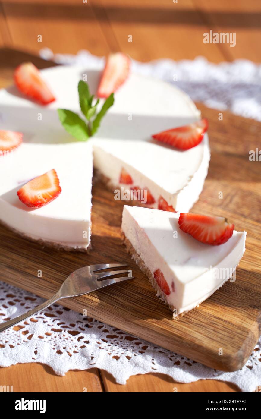 slice of strawberry cheesecake on white background, selective focus, square image. Stock Photo