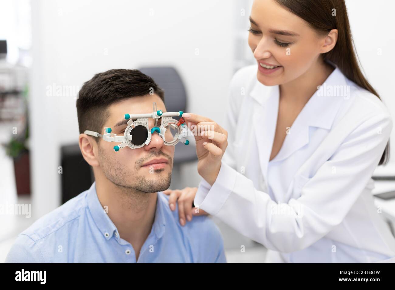 Optometrist checking patients vision with trial frame Stock Photo - Alamy