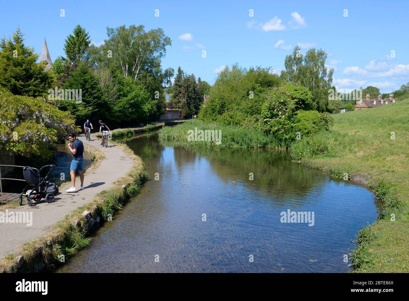 Loose Village, Kent, UK. 25th May, 2020. People make the most of the fine weather to take a walk along the narrow footpath in Loose Brooks, the stream running through the village. The one-way system suggested at each end is not universally followed Credit: Phil Robinson/Alamy Live News Stock Photo