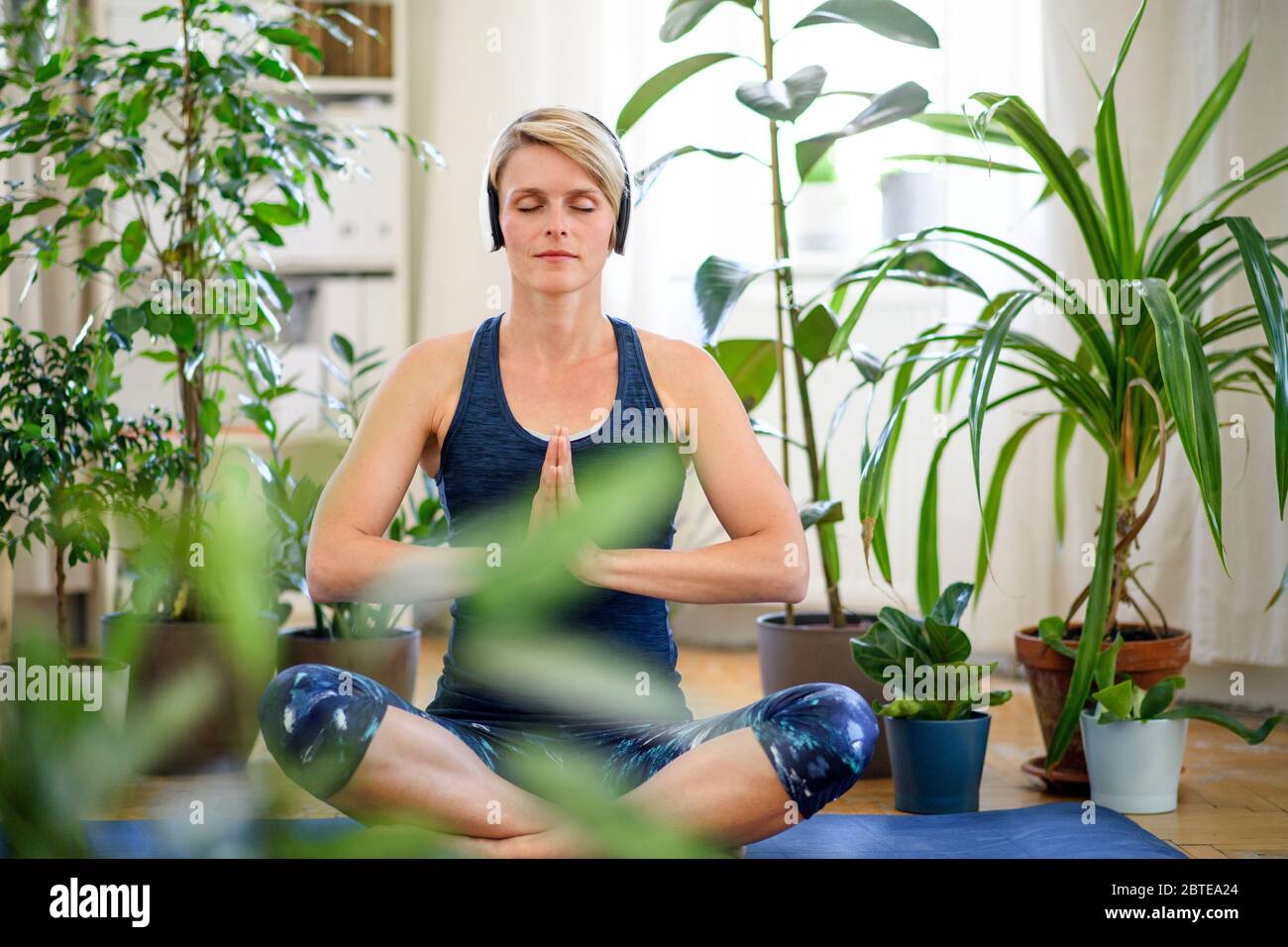 Front view of young woman indoors at home, doing yoga exercise. Stock Photo