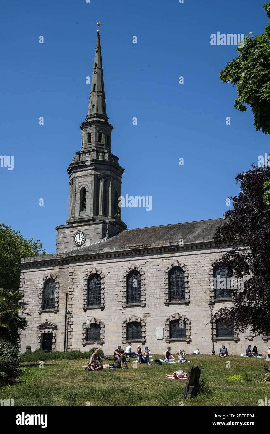 Hockley, Birmingham, May 25th 2020. Sunbathers enjoy the hot Bank Holiday weather in the grounds of St Paul's Church in the Hockley area of Birmingham on Monday afternoon. The sun seekers social distanced from each other to maintain government guidelines during the COVID-19 crisis. Credit: Sam Holiday/Alamy Live News Stock Photo