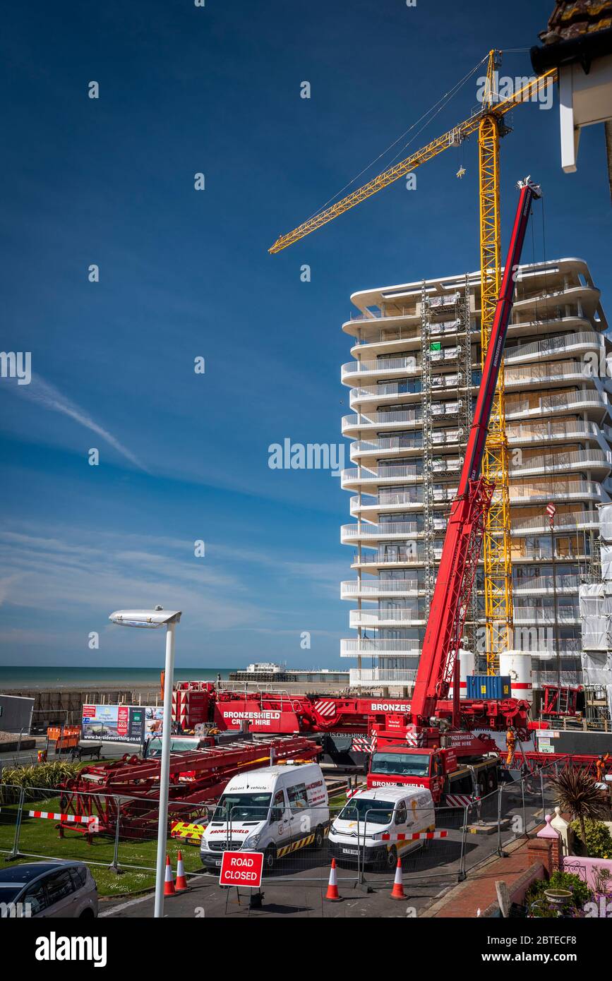 A massive crane  dismantling a large crane on a building site. Stock Photo
