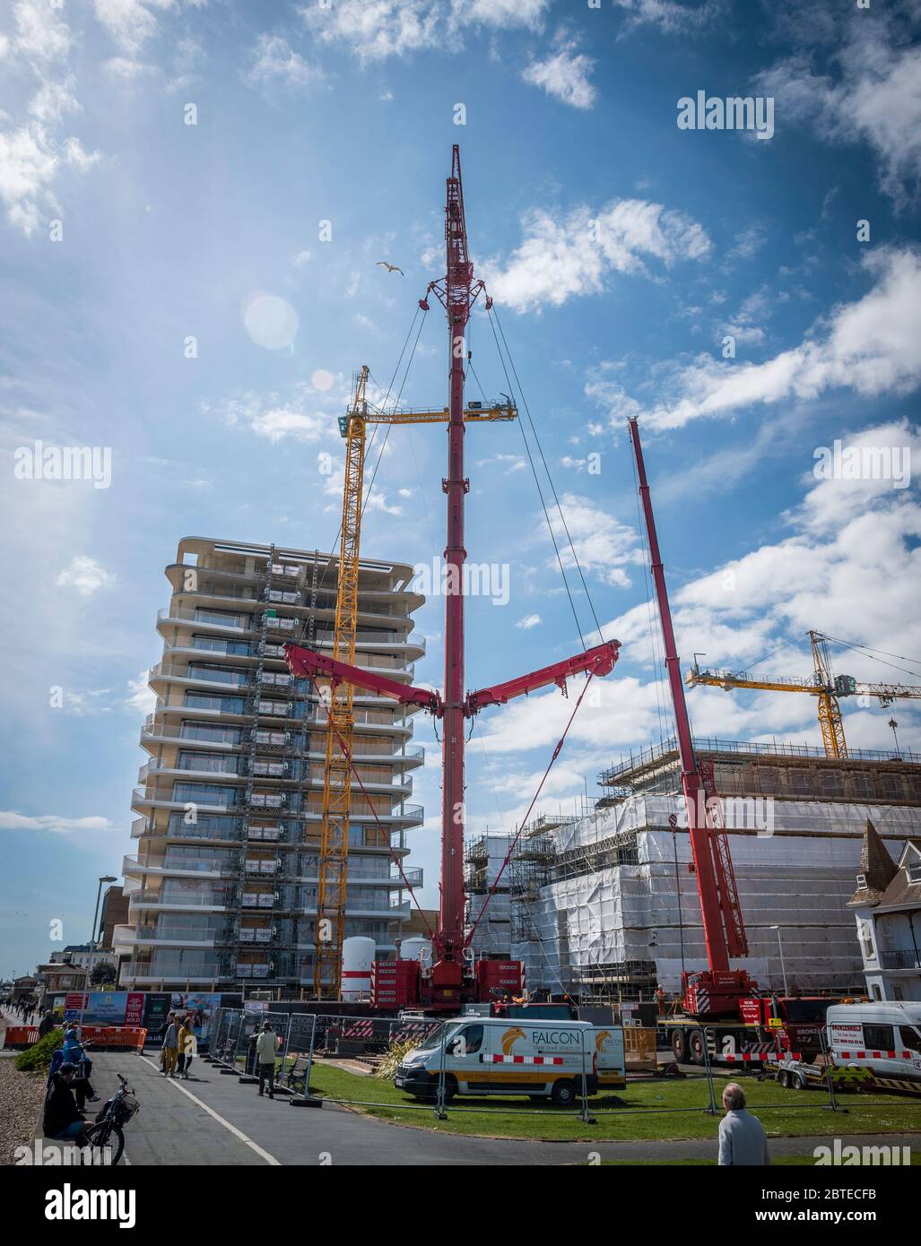 A massive crane  dismantling a large crane on a building site. Stock Photo