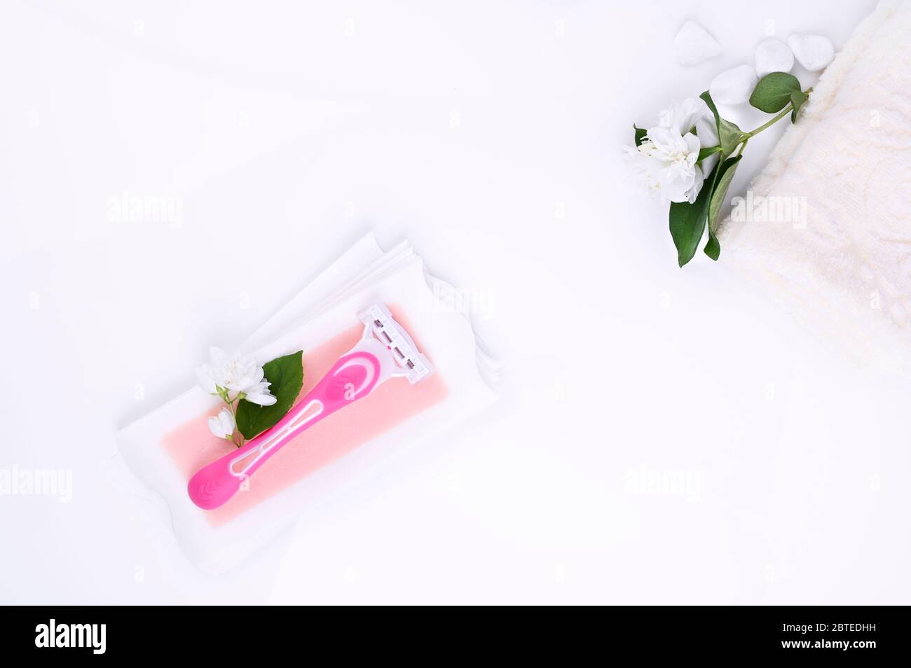 a set of different means for epilation on a colored background. Removal of unwanted hair. Body care products, towels, jasmine flowers, wax strips, razor. Minimalism, top view. flatlay. Stock Photo