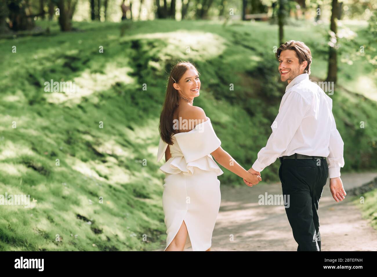 Couple Walking In Park Holding Hands Celebrating Wedding Without Guests ...
