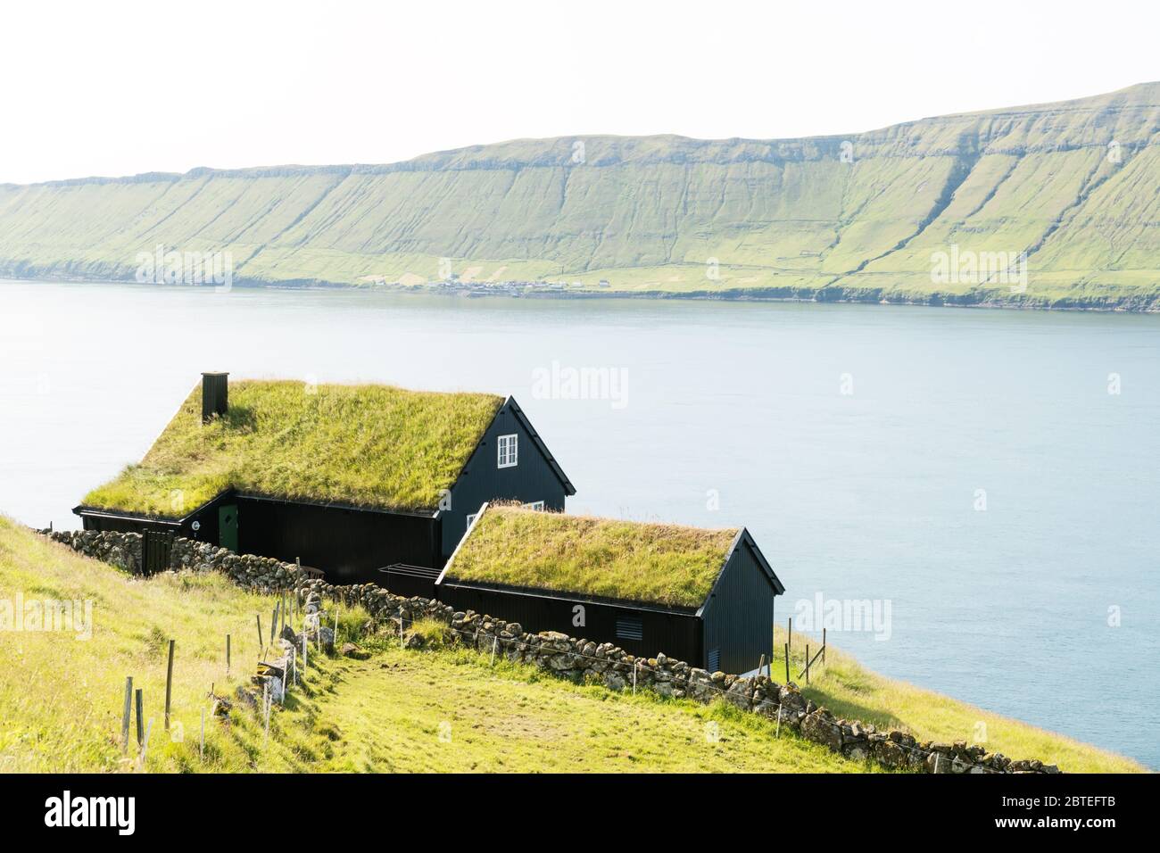 Foggy morning view of a house with grass roof in the Velbastadur village on Streymoy island, Faroe islands, Denmark. Landscape photography Stock Photo