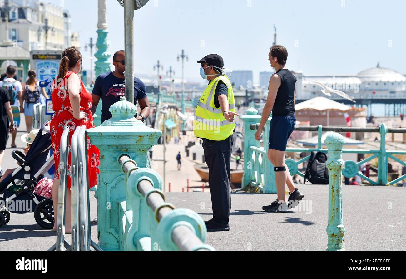 Brighton UK 25th May 2020 - Stewards talk to visitors as parts of Brighton beach are being restricted in numbers for the bank holiday as they enjoy the hot sunshine with temperatures forecast to reach the high 20s in the south east of England during the Coronavirus COVID-19 pandemic crisis  . Credit: Simon Dack / Alamy Live News Stock Photo