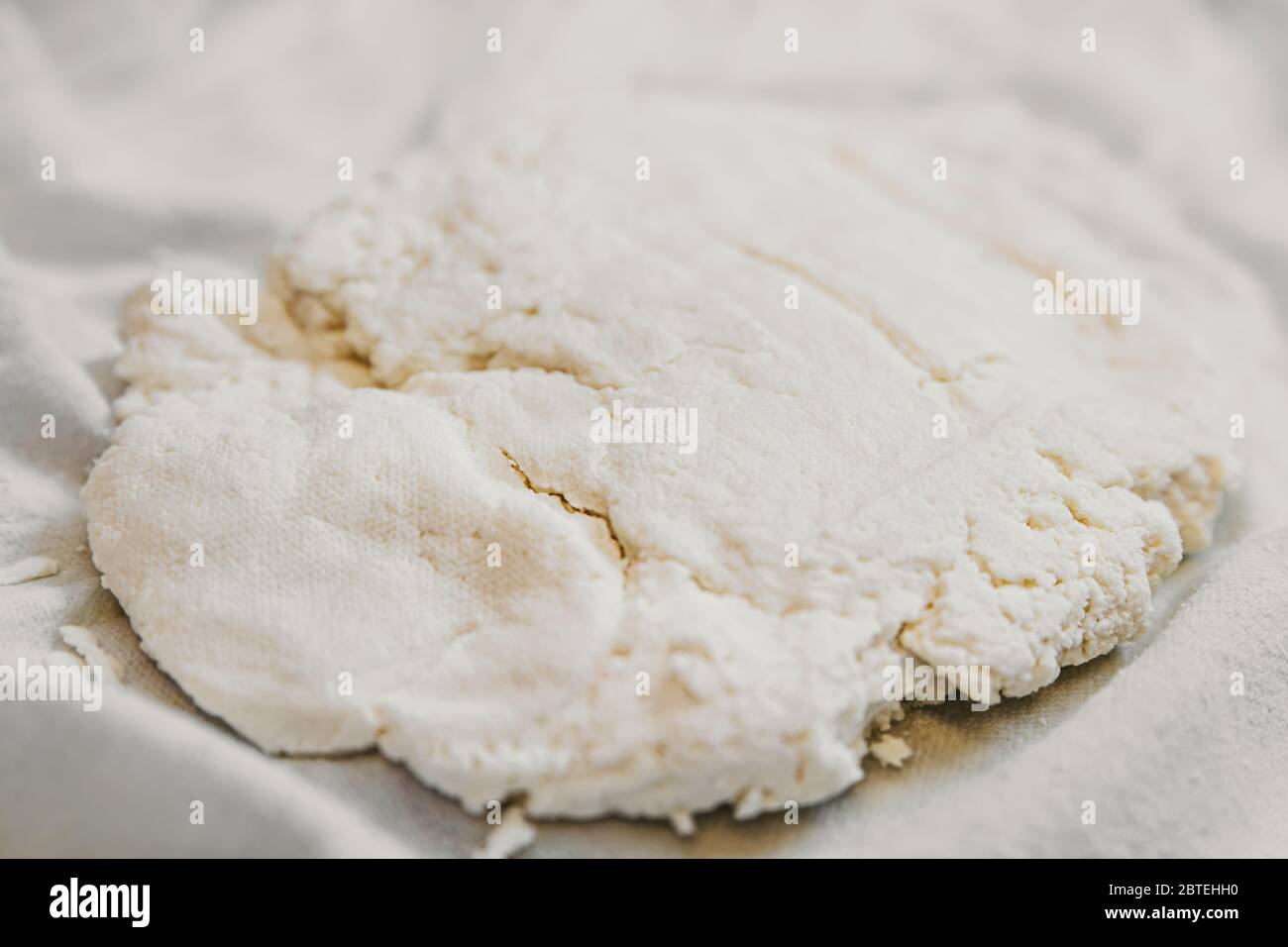 Fresh cheese making process, wrung cottage cheese or paneer on cotton cloth, homemade Stock Photo