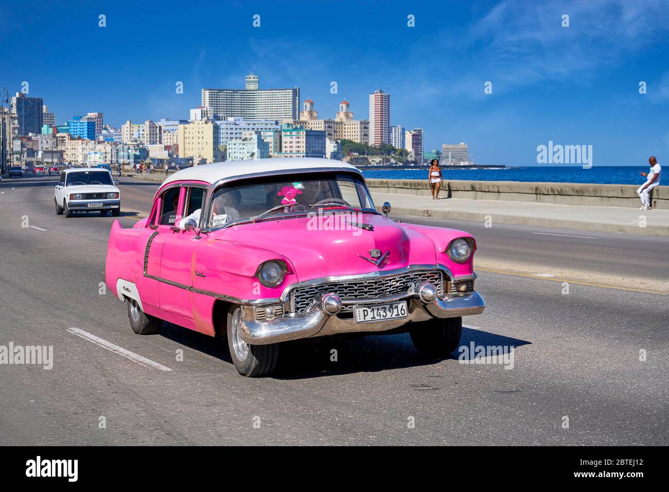 Classic American pink car driving along the Malecon, Havana, Cuba Stock Photo