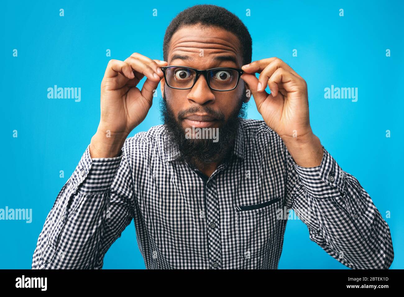 Surprised african american guy touching his eyewear Stock Photo Alamy