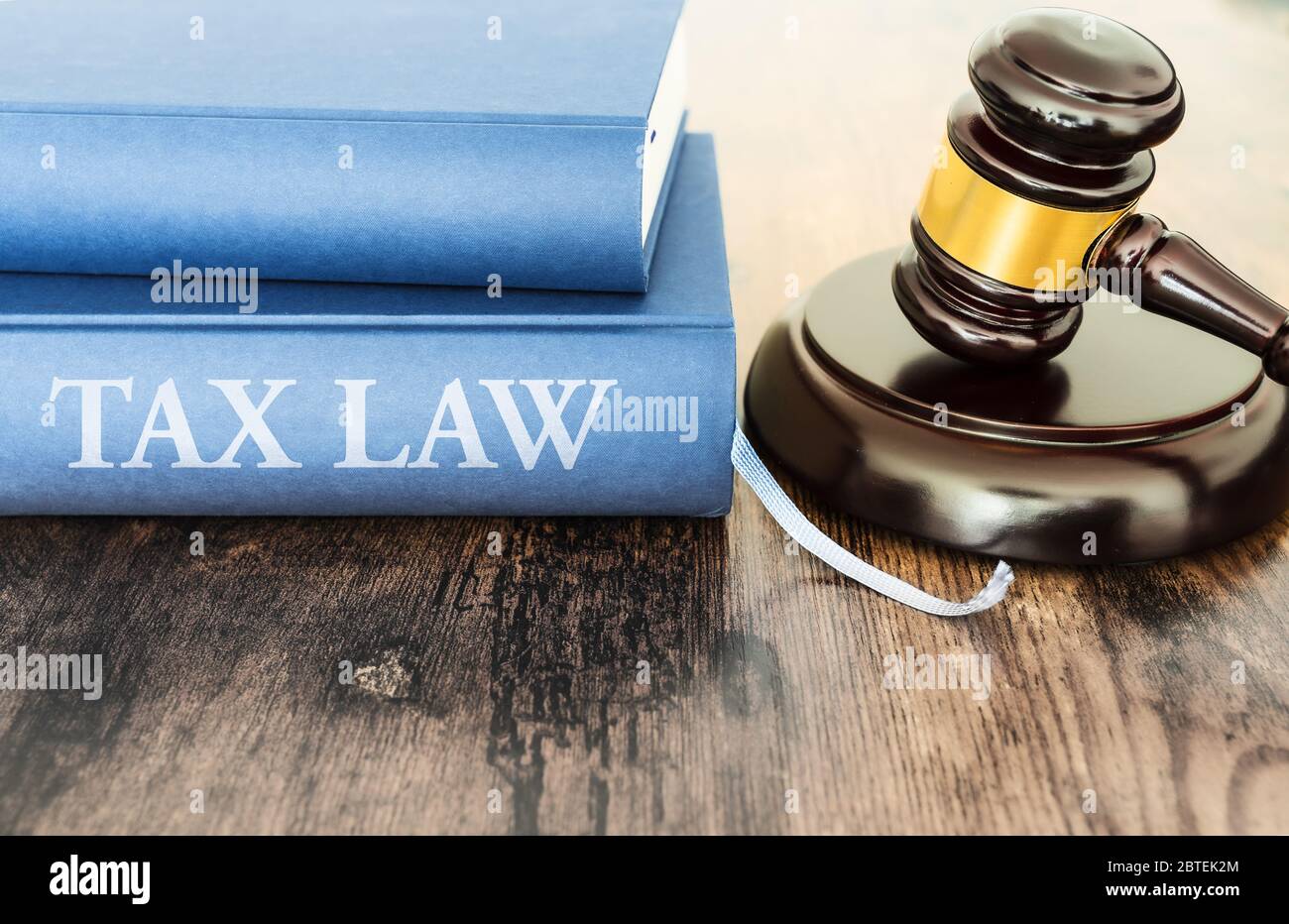 close-up of judge gavel and book with text TAX LAW on rustic wooden table Stock Photo