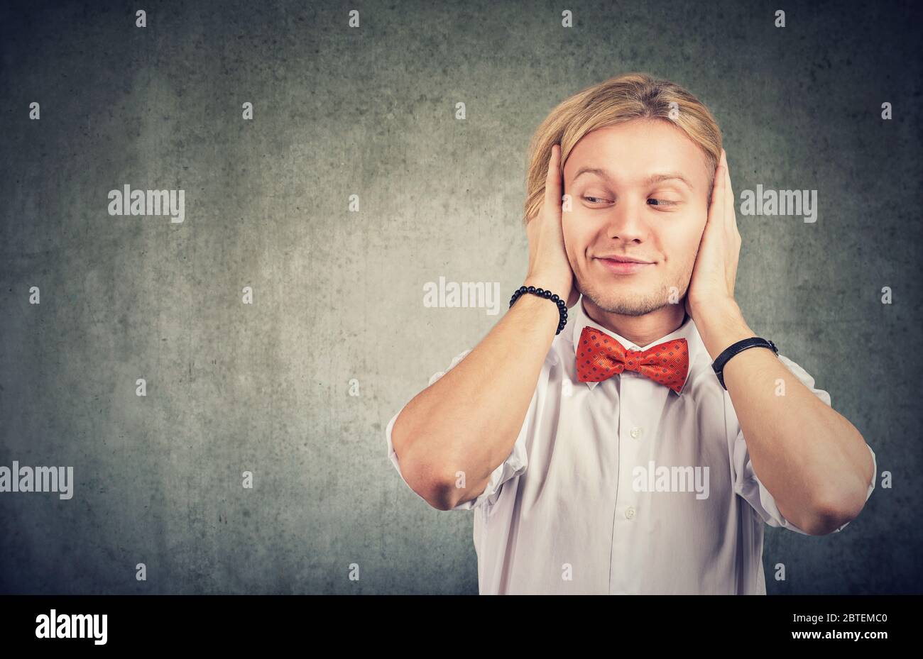 Young happy man avoiding background noise and rumours Stock Photo