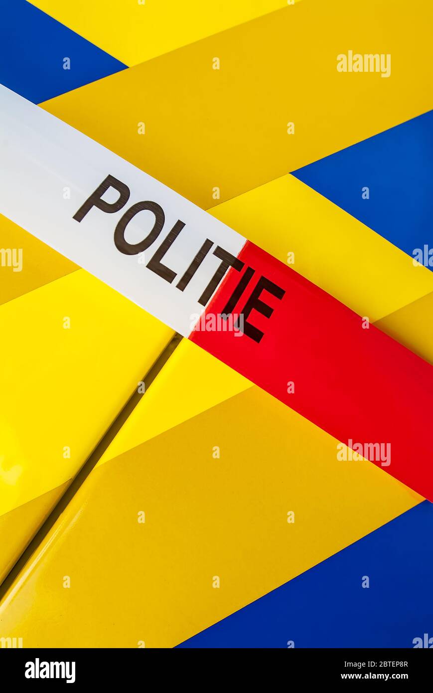 Red with white crime scene tape with the Dutch text 'police' on a police car Stock Photo