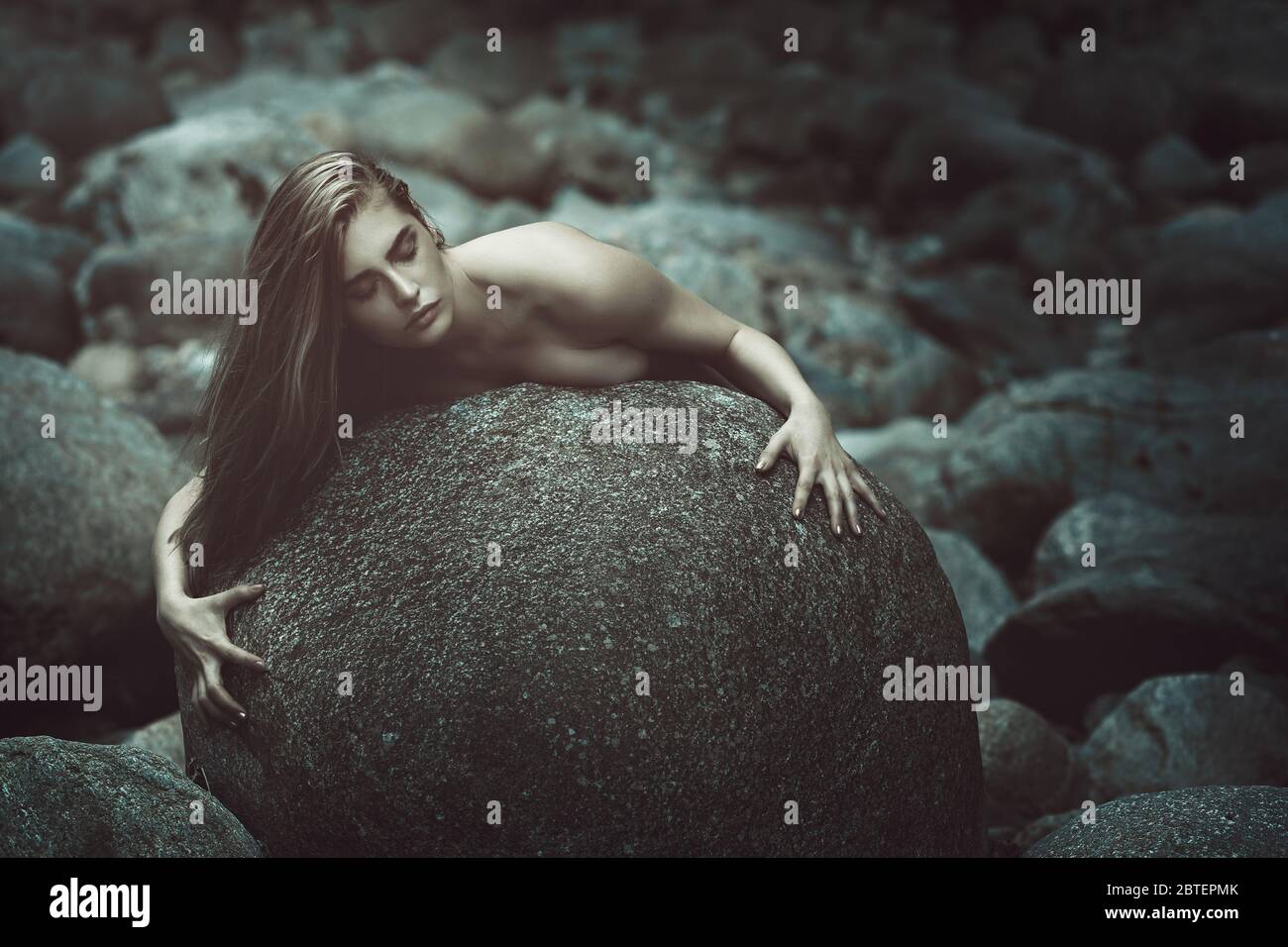 Dark alien woman rising from stones . Surreal and horror Stock Photo