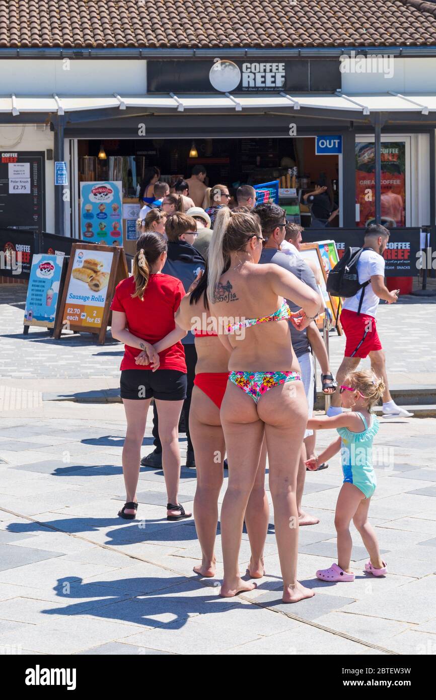 Bournemouth, Dorset UK. 25th May 2020. Social distancing as visitors queue for drinks and ice creams at Coffee Reef on a scorching hot day at Bournemouth beaches with clear blue skies and unbroken sunshine, as temperatures soar on Bank Holiday Monday. Sunseekers flock to the seaside and beaches are packed. Credit: Carolyn Jenkins/Alamy Live News Stock Photo