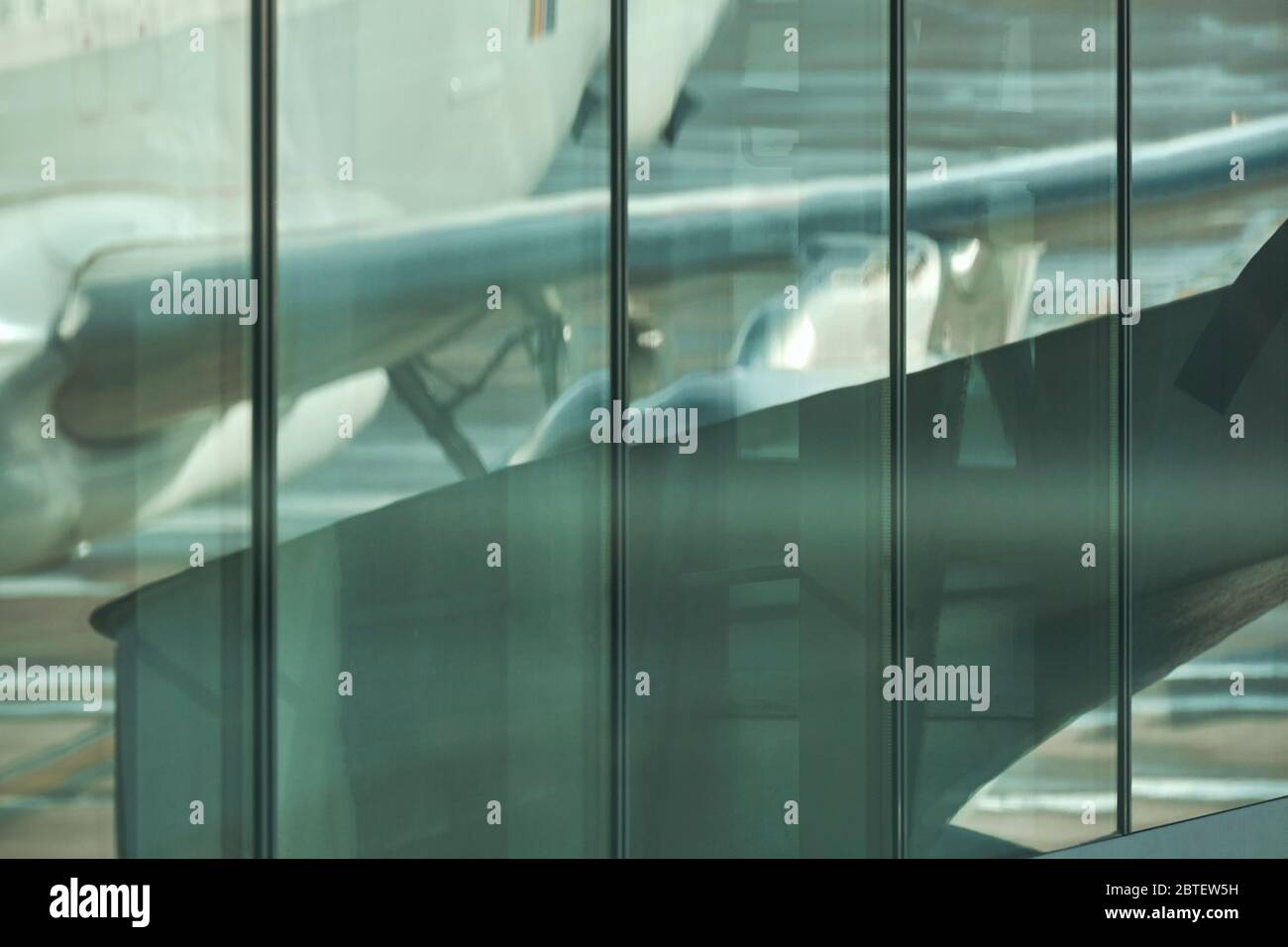 airbus aeroplane wing reflected in a glass facade of airport, closeup shot Stock Photo