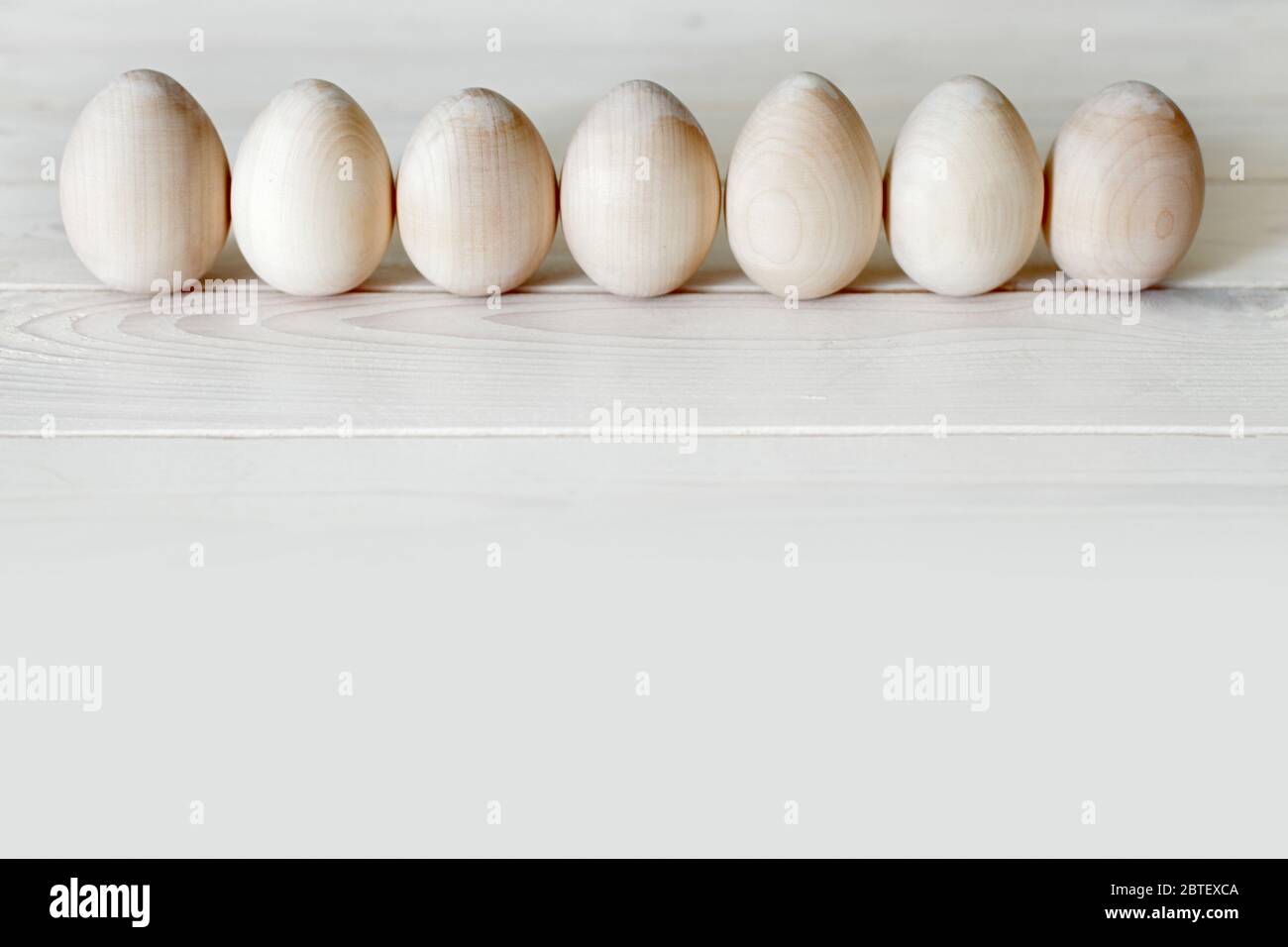 Wooden Easter eggs are not painted lined up. Stock Photo
