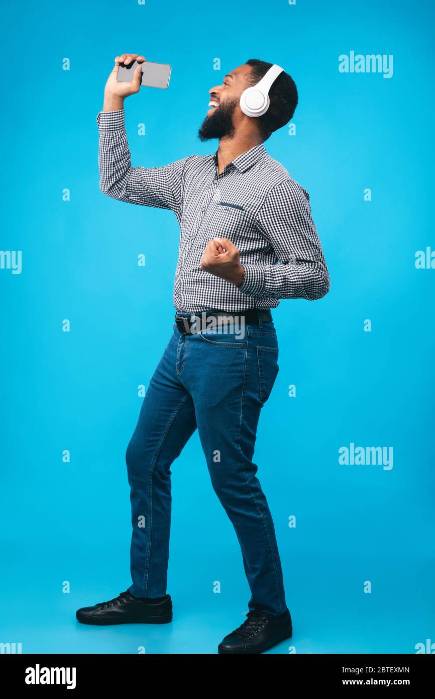 Afro man singing using smartphone as microphone Stock Photo