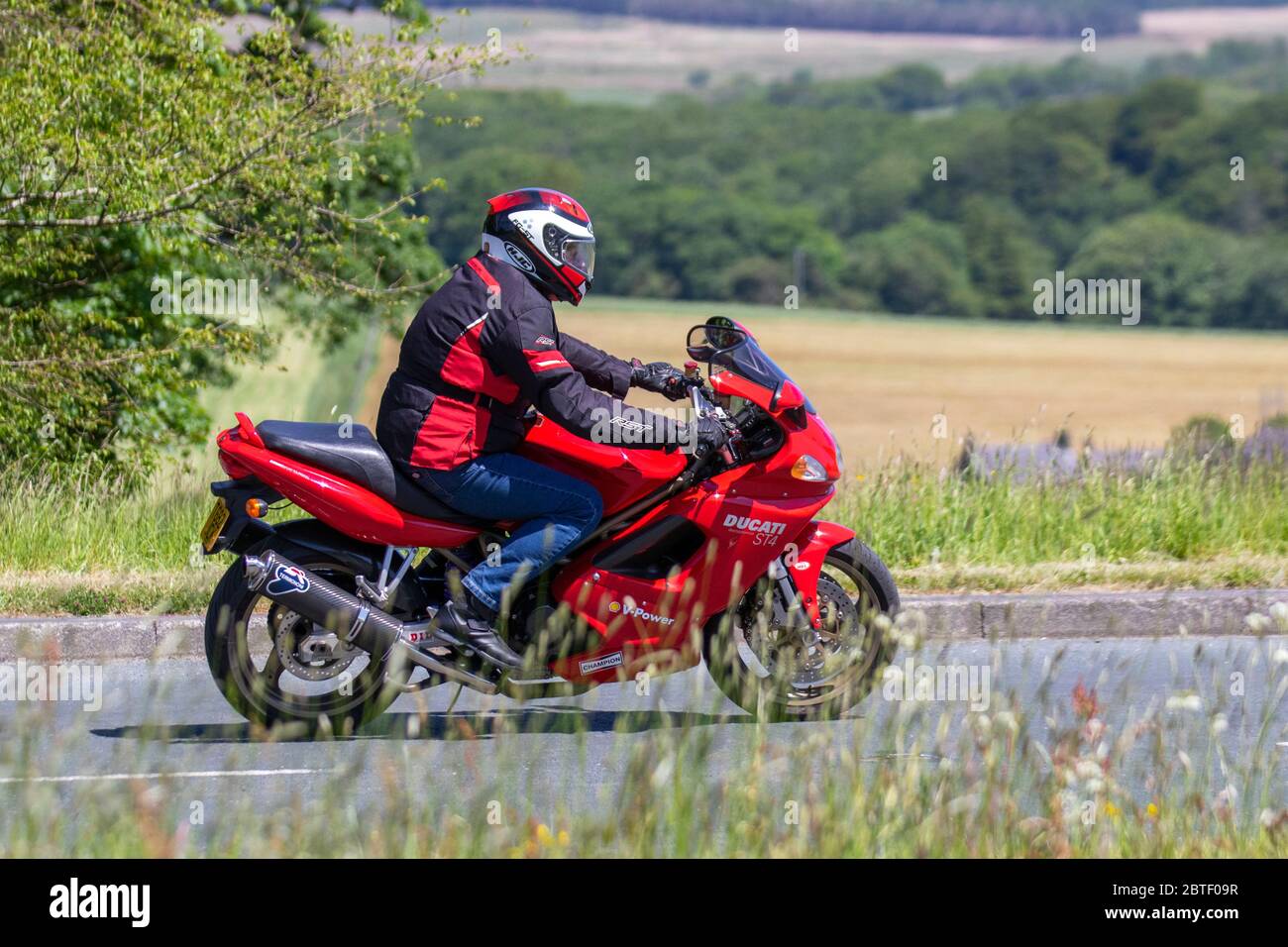 199 red Ducati; Motorbike rider; two wheeled transport, motorcycles, vehicle, roads, motorbikes, bike riders motoring in Rivington UK Stock Photo
